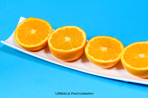 Oranges on a plate with blue background